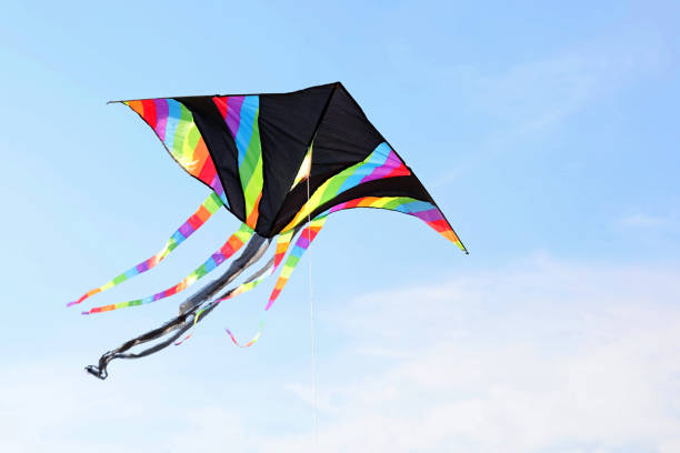 istock black kite with colorful stripes flies in the blue sky attached to the string 1431599314