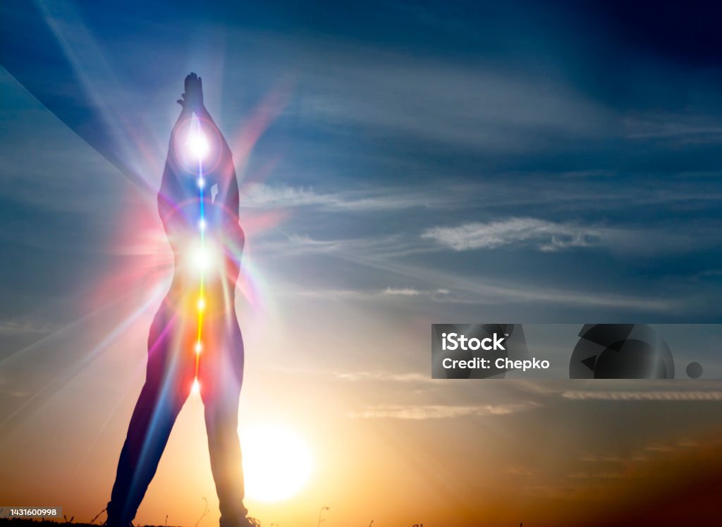 Silhouette of woman in yoga pose on beach sunset view, glowing s woman in yoga pose on beach sunset view, glowing seven all chakra. Kundalini energy. girl practicing meditation outdoors. Silhouette. Vitality Stock Photo