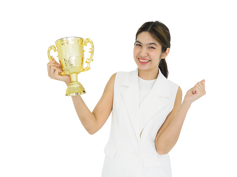 Asian woman in white dress holding the trophy received from the work done proudly. Portrait on white background with studio light.