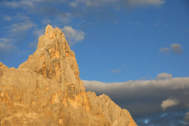 mountain called Cimon della Pala on Dolomites in Italy colored orange by optical phenomenona called Alpenglow which reflects the light of the setting sun