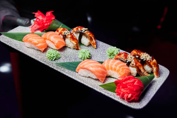 istock The waiter holds a plate of sushi based on salmon and eel 1431606592