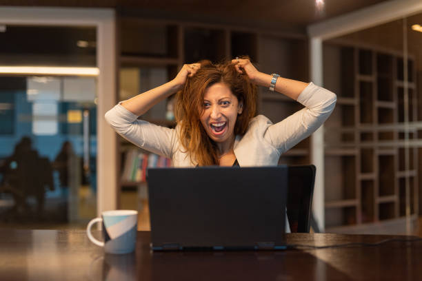 istock Angry and frustrated woman using laptop computer in office 1431607681
