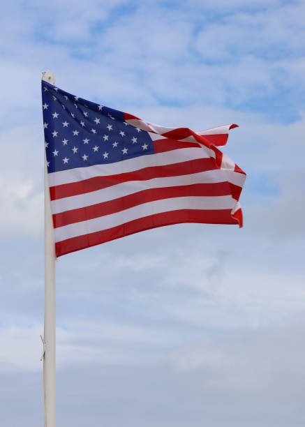 istock Big American Flag wavings on the blue sky 1431610668