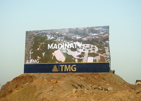 Cairo, Egypt, September 24 2022: A large Advertisement LCD LED TV on a sand hill for TMG Talaat Moustafa Group, one of the largest conglomerates in Egypt, Madinaty and Al Rehab city in New Cairo, selective focus