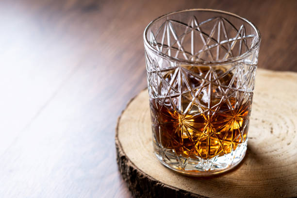 istock Scotch whiskey glass, on wooden table 1431614412
