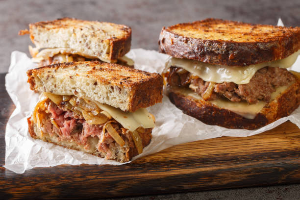 istock classic beef patty melt sandwich using crispy rye bread, cheese, and tender onions closeup on the wooden board. Horizontal 1431615498