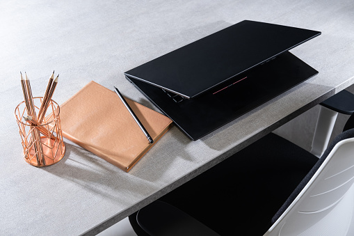 Half closed laptop with rose gold accessories.