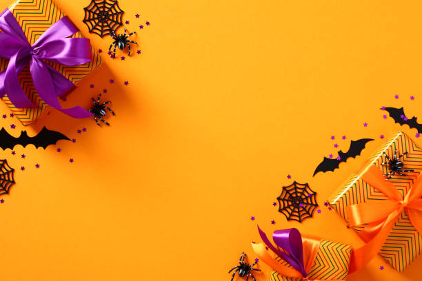 istock Happy Halloween holiday concept. Flat lay composition with Halloween decorations, gift boxes, spiders, bats, confetti on orange background. Top view with copy space. 1431624053