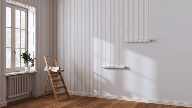 Empty room with white walls and parquet floor, shits of striped beige wallpaper on the wall with copy space. Housework concept stock photo