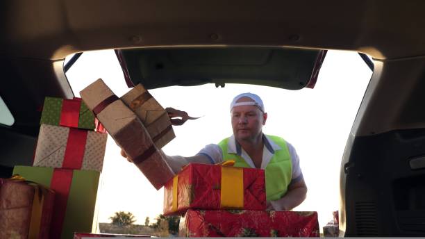 istock delivery service. deliveryman in protective mask. courier unloads boxes. gift boxes in car. beautifully wrapped parcels. view from inside the car. donation, charity or delivery concept. 1431626005