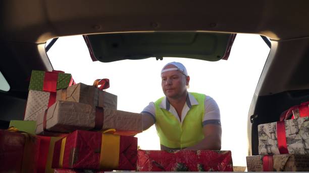 istock delivery service. deliveryman loads boxes. gift boxes in car. beautifully wrapped parcels. view from inside the car. donation, charity or delivery concept. 1431626219