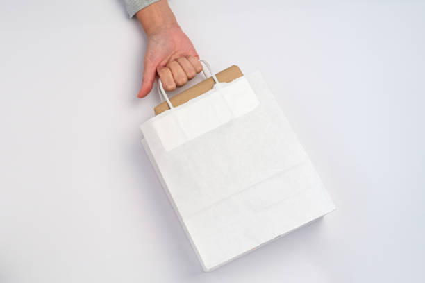 carrying a package inside a white paper bag, shopping concept stock photo