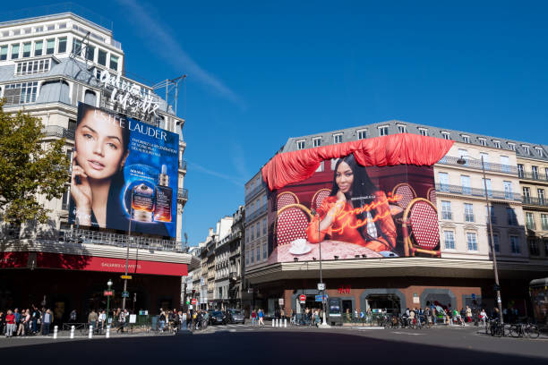 werbung in paris, frankreich: estée lauder werbetafel auf dem gebäude der galeries lafayette und anzeige der brasserie hennes auf dem h- und m-gebäude - building exterior built structure street paris france stock-fotos und bilder