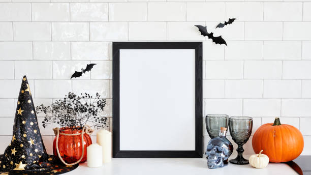 istock Black picture frame mockup with Halloween decorations on table on brick wall background. Scandinavian home interior design. Halloween holiday celebration concept. 1431633182