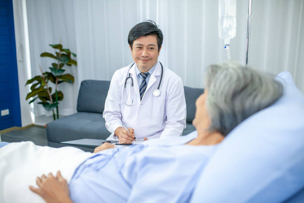 istock asian doctor with stethoscope and document folder, examine the symptom for patient in the recovery room. Healthcare and medicine concept. 1431634119