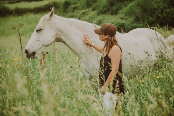 istock Woman with a white horse 1431637031