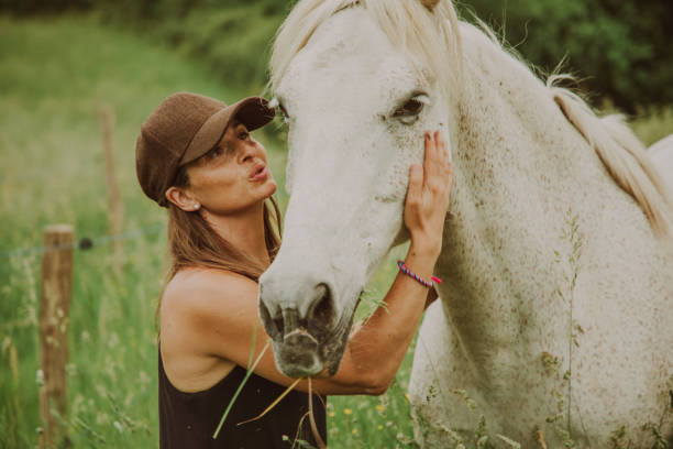 istock Woman with a white horse 1431637042