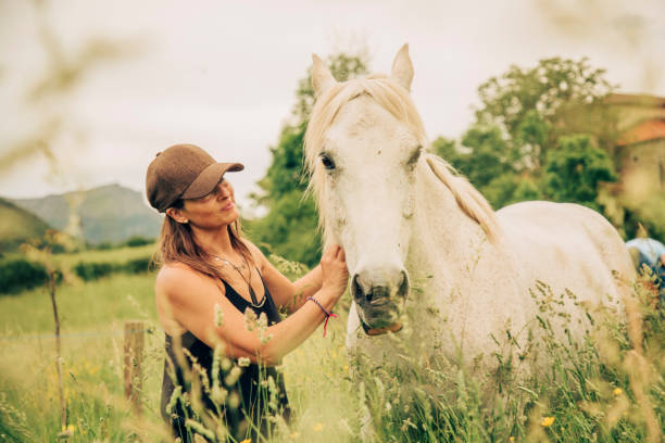 istock Woman with a white horse 1431637046