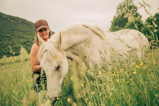 istock Woman with a white horse 1431637052