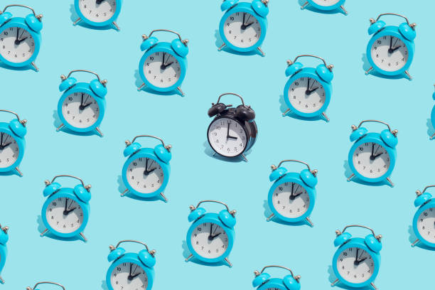 istock Seamless pattern of blue retro alarm clocks  show 2 o'clock and one black shows 3. Changing clock from summer time to winter time. Shifting the clock hands back in autumn. 1431637759