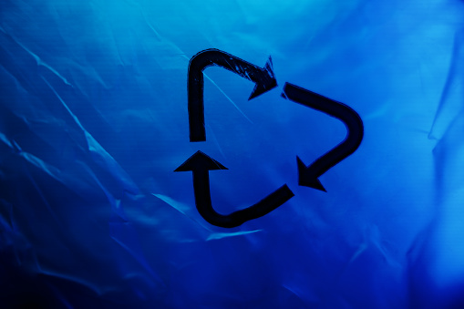 Plastic bag under the blue light with recycling icon