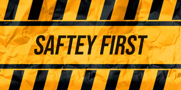 Safety first typography written on yellow warning lines with paper texture background. Safety concept wallpaper Safety first typography written on yellow warning lines with paper texture background. Safety concept safety first stock illustrations