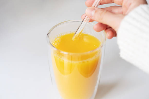 istock Woman drinking juice with a glass straw 1431640194