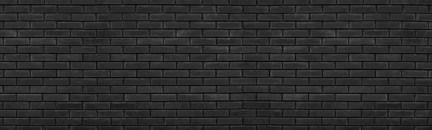 Old black brick wall wide texture. Dark shabby brickwork grunge panoramic background