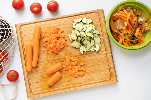 Chopping vegetables and making compost from peelings - table top view