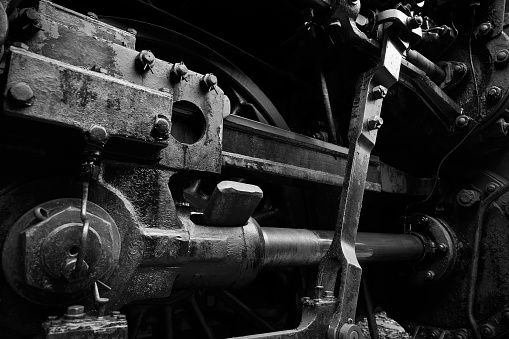 Close-up of coupling rods of an old locomotive with textured metal surface and bolts - Black & White Photography