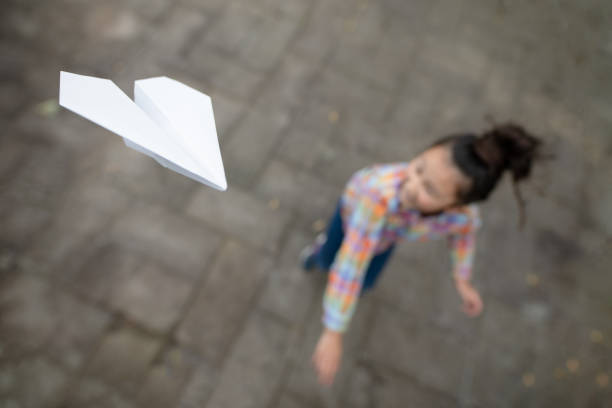 girl flying a paper plane