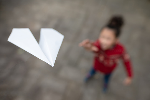 girl flying a paper plane