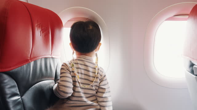 Asian parent with two sons traveling by commercial plane