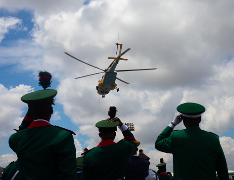 Member of Nigeria Arm force hold their cap down from heavy wind blowed from the Nigeria Air For 502 Helicopter during 62nd independence day celebration at eagle square, Abuja, Nigeria.