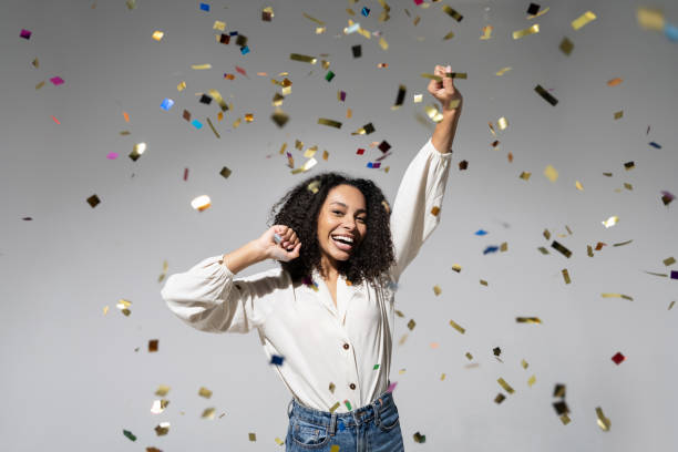 istock Joyful woman laughing, dancing and has fun with falling confetti. Enjoying life, celebration concepts 1431663906