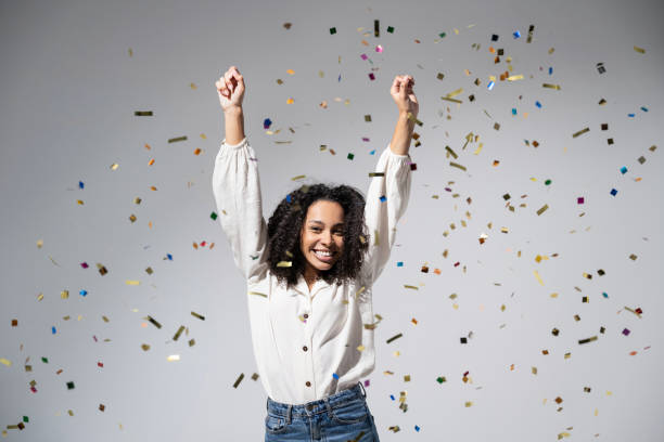 istock Joyful woman laughing, dancing and has fun with falling confetti. Enjoying life, celebration concepts 1431663923