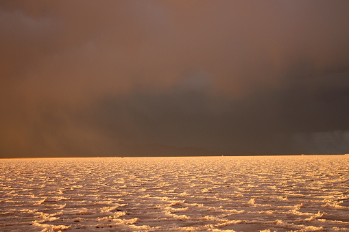 Storm at salt flat desert on sunset
