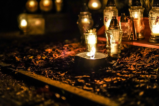 Grave memorial candles as a symbol of remembrance of the dead in the christian graveyard on 1 november