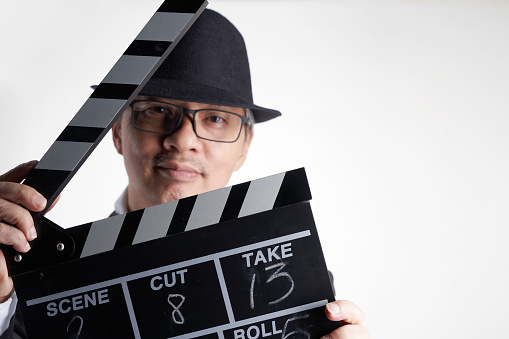 film director holding clapper board against white background