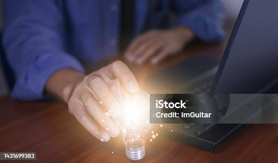 istock The hand of a man with a light bulb and he is using a notebook computer. Thinking differently creates inspiration and ideas.New innovations and technologies can always come from creative and different ideas. 1431699383