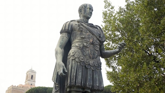 The first light of the evening envelops the statue of the Emperor Gaius Iulius Caesar Augustus, also know as Octavian or Augustus, along the Fori Imperiali boulevard, in the ancient and imperial heart of Rome. This bronze statue, placed in front of the Trajan's Forum, is a copy of the marble original currently preserved in the Vatican Museums. Caesar Augustus was the first Roman emperor, revered as father of the homeland (Patri Patriae) and artecife of a long period of domination, prosperity and peace throughout the empire, known as Pax Romana. In the background the Forum of Trajan and the baroque dome of the church of the Santissimo Nome di Maria. In 1980 the historic center of Rome was declared a World Heritage Site by Unesco. Image in high definition format.