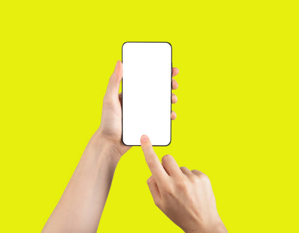 istock Mobile phone screen mockup in hand, finger pressing, clicking on vertical white blank display on yellow 1431709730
