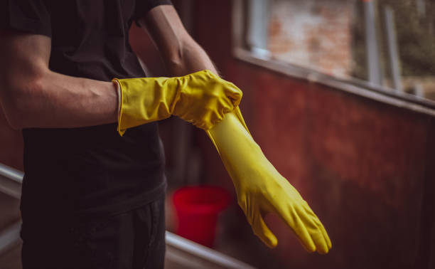istock Young caucasian man puts yellow rubber gloves on his hands getting ready to wash window frames 1431709846