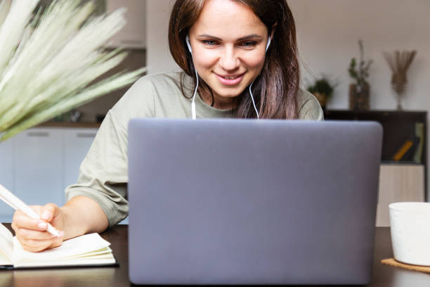 istock Brown hair woman working from home participating at video call using her laptop. 1431713017