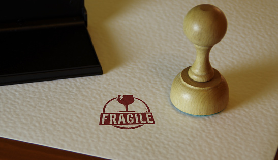 Fragile stamp and stamping hand. Careful shipping and handle with care concept.