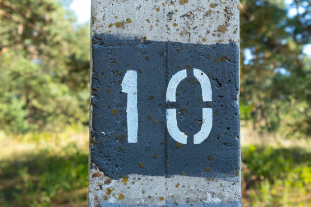 istock The number net stencil on the surface of a concrete pillar. Numeral 10 close-up white text on a black background 1431718575