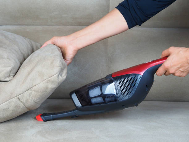 istock Woman with hand vacuum cleaner 1431718665