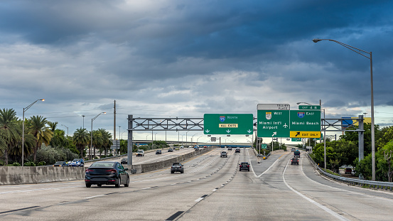 Rush hour traffic on I-95 next to downtown Miami on a stormy day.