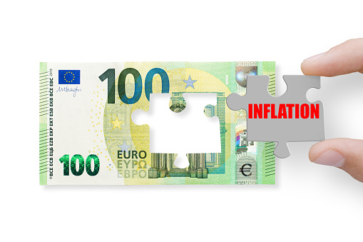 The concept of financial crisis and recession. 100 euros note isolated on a white background with word inflation
