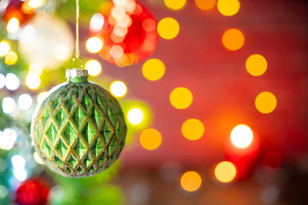 Christmas fir tree background with baubles and glowing Christmas lights bokeh